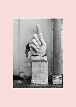 Foto in bianco e nero di una scultura in pietra a forma di mano su piedistallo