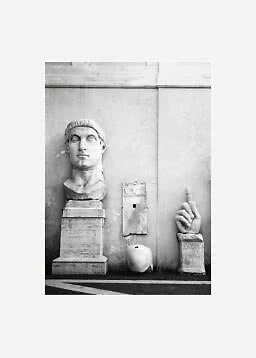 Foto in bianco e nero di sculture antiche in marmo, una grande testa e una mano con dito alzato