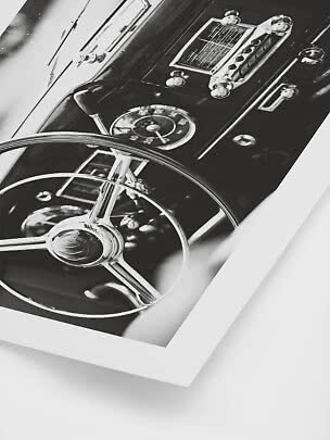 Primo piano in bianco e nero di volante e cruscotto di un'auto d'epoca