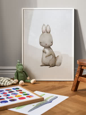 Indrammet kaninplakat i bløde beige toner lænet op ad væggen på børneværelse