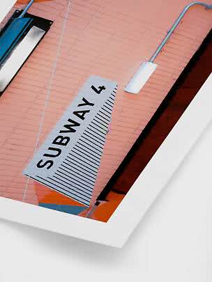 Panneau « Subway 4 » sur mur de briques rose avec lampes et conduits apparents