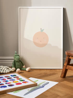 Gerahmtes Kinderposter mit süßem Pfirsichgesicht, an der Wand auf Holzboden angelehnt