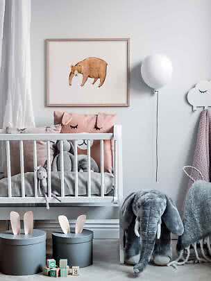 Chambre de bébé avec lit blanc, peluches et affiche d’ours encadrée au mur