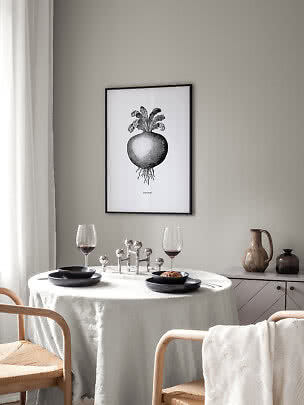 Gerahmtes Schwarz-Weiß-Poster mit Kohlrabi über einem gedeckten Esstisch in hellem Raum