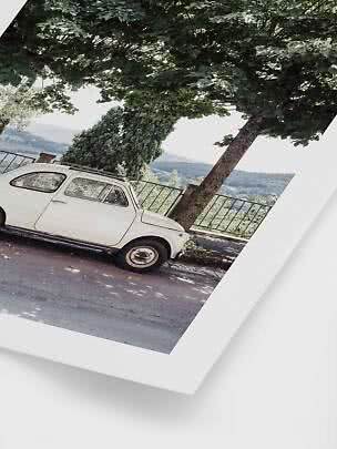 Poster of a white vintage car parked under a large tree overlooking hills