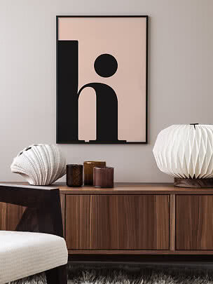 Gerahmtes abstraktes Poster mit schwarzer grafischer Form auf rosigem Hintergrund über Holzsideboard
