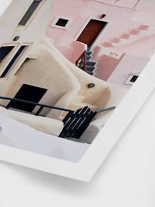 Angled photo of pink and white buildings with stairs, doors, and railings