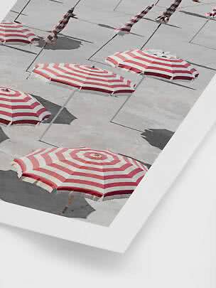 Rood-wit gestreepte parasols op een licht betonnen terras van bovenaf