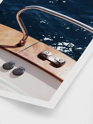 Dos almohadillas adhesivas redondas negras delante de una foto del borde de un barco junto al agua