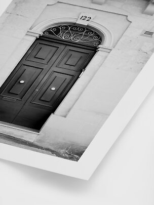 Black-and-white photo of a dark double door with ornate fanlight and house number 122