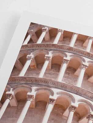 Close-up of the Leaning Tower of Pisa with arches and columns in soft sunlight