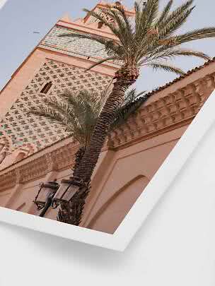 Palm trees in front of an ornate pink tower with blue-green tiles, viewed from below