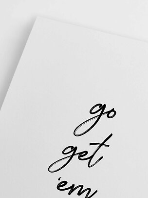 Hvidt kort med sort kalligrafi, hvor teksten "go get ’em" delvist ses