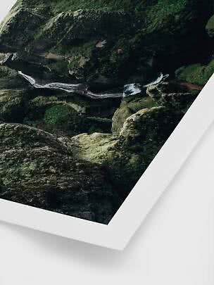 Veduta aerea di una piccola cascata tra rocce ricoperte di muschio, stampata come poster