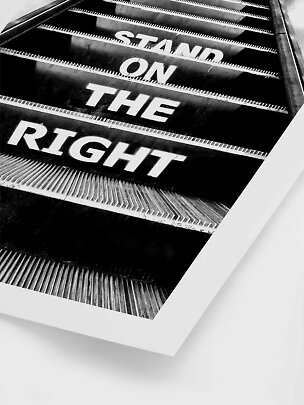 Zwart-wit poster van een roltrap met de tekst "Stand on the right" op de treden