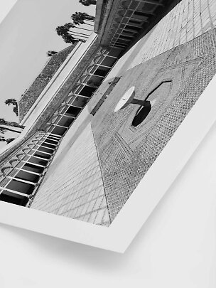 Foto en blanco y negro de patio con suelo de mosaico, fuente y palmeras