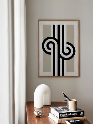 Affiche abstraite encadrée au-dessus d'une table en bois avec livres, tasse et sculpture blanche