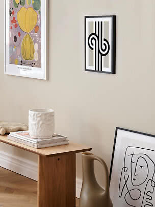 Affiche graphique abstraite noir et blanc dans un cadre noir sur mur beige