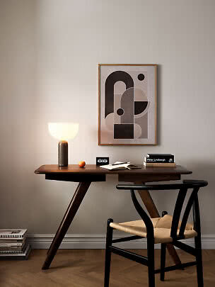 Modern bureau met brandende tafellamp, stoel en abstracte poster aan de muur