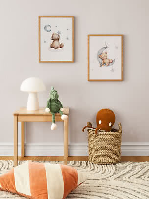 Kinderzimmer mit zwei gerahmten Teddybildern, Tischlampe, grüner Strickpuppe und Korb mit Oktopus.