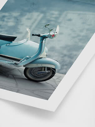 Nahaufnahme eines hellblauen Vintage-Rollers mit Windschutzscheiben vor blau-grauer Wand