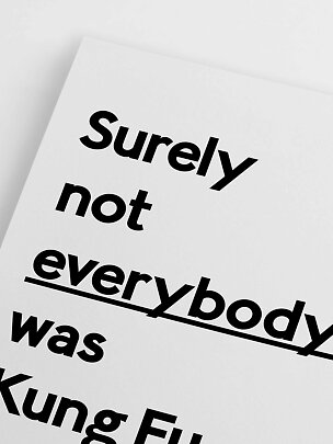 Närbild av vit poster med svart typografisk text i modern layout