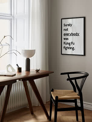 Inramad typografiposter med texten "Surely not everybody was Kung Fu fighting" på beige vägg