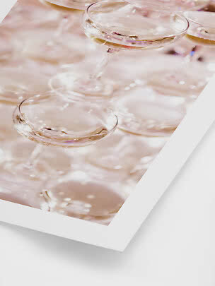 Primo piano di diversi eleganti bicchieri coupé con spumante chiaro in delicate tonalità rosa
