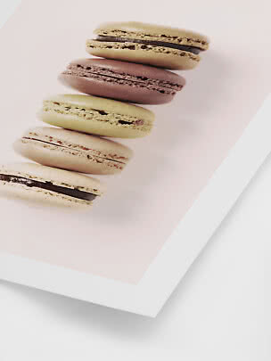 Stabel af fem farverige macarons på lyserød baggrund