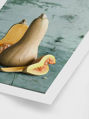 Whole and sliced butternut squash on a rustic blue-green wooden surface