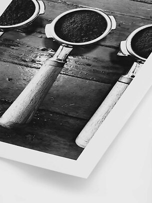 Stampa in bianco e nero con tre portafiltri con manici in legno su un tavolo rustico