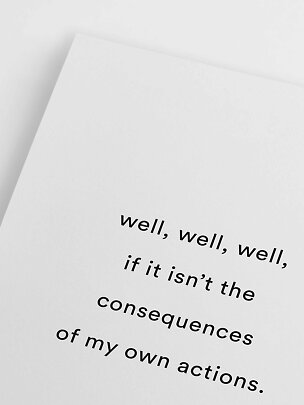 White art print with black English quote, angled on a light background
