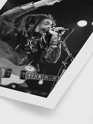 Sort-hvid plakat af sanger med dreadlocks, mikrofon og elguitar på scenen
