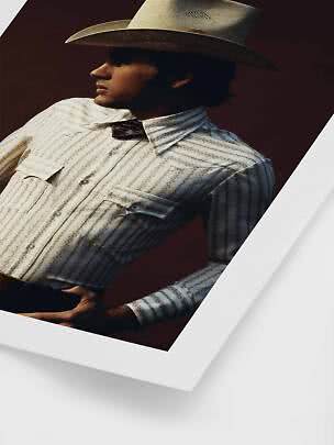 Homme de profil en chemise western rayée, nœud papillon et chapeau cowboy