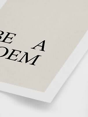 Primo piano di poster minimalista con tipografia nera su carta color crema in cornice bianca