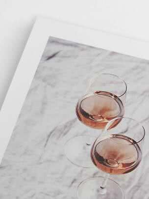 Gedrucktes Foto von zwei Weingläsern mit Rosé auf einem Marmortisch