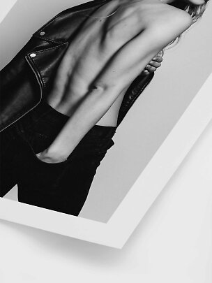 Photo de mode en noir et blanc d’un modèle en jean noir avec veste en cuir noir sur le dos