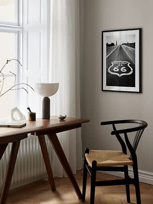 Poster Route 66 in bianco e nero con cornice nera sopra scrivania e sedia