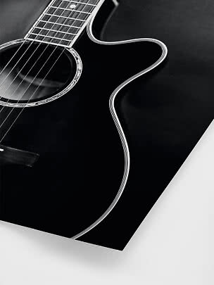 Close-up of a black acoustic guitar with cutaway and glossy finish
