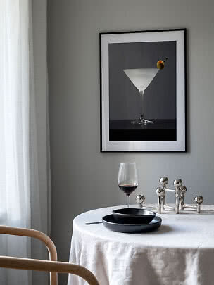 Gerahmtes Poster mit Cocktailglas und Olive über einem gedeckten Tisch