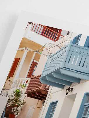 Narrow courtyard with white walls, colorful balconies, and a clothes drying rack
