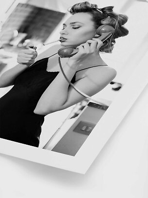 Black-and-white photo of woman with hair rollers, phone handset, cigarette and lighter