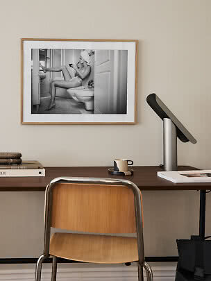 Gerahmter Schwarz-Weiß-Fotodruck über Schreibtisch mit Frau im Badezimmer