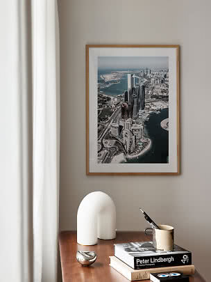Photo urbaine encadrée au-dessus d'une table en bois avec livres, sculpture et tasse avec stylo