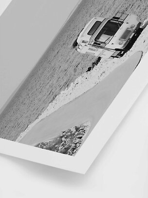 Schwarz-Weiß-Fotodruck eines Wohnmobils an einer Küstenstraße mit weißem Passepartout.