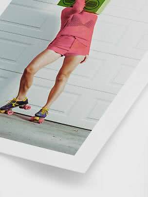 Person in pinker Sportkleidung auf Rollschuhen vor weißem Garagentor mit grünem Ghettoblaster