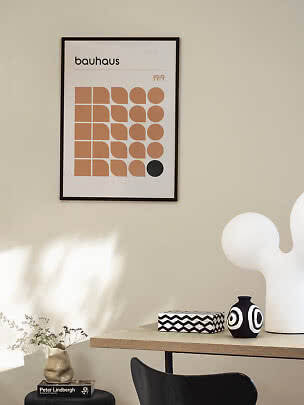 Indrammet Bauhaus-plakat med geometriske former i beige og sort på lys væg