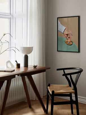 Angolo studio moderno con tavolo in legno, sedia nera, lampada da tavolo e arte incorniciata