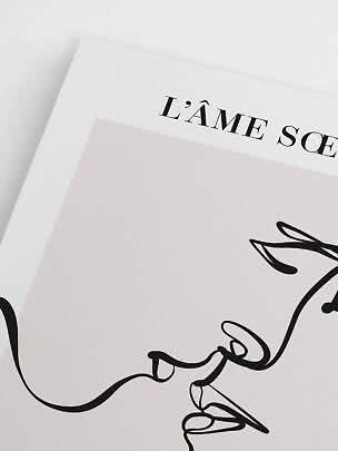 Primo piano di stampa artistica minimalista con disegno a linea nera e testo "L’ÂME SOE"