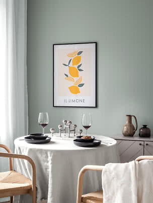 Ingelijste citroenposter aan groene muur boven gedekte eettafel